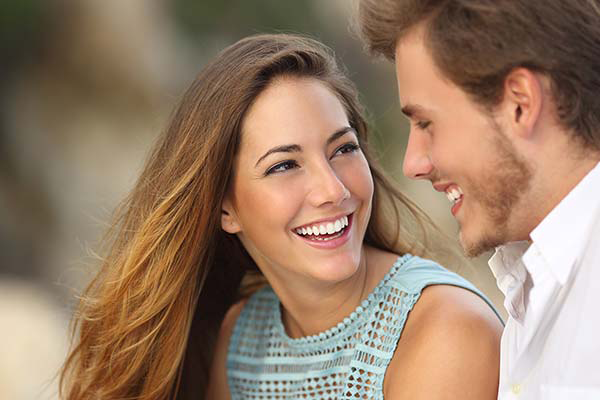 a man and woman smiling at each other intimately